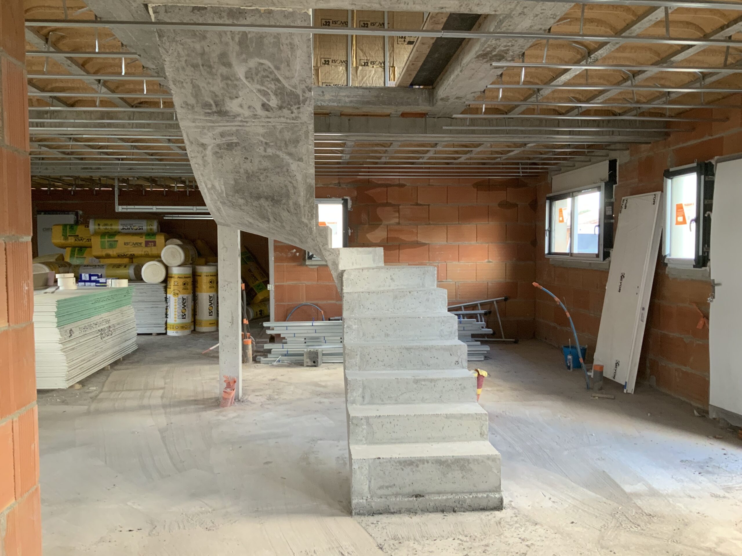 Audacieux escalier à paillasse deux quart tournant en béton brut de