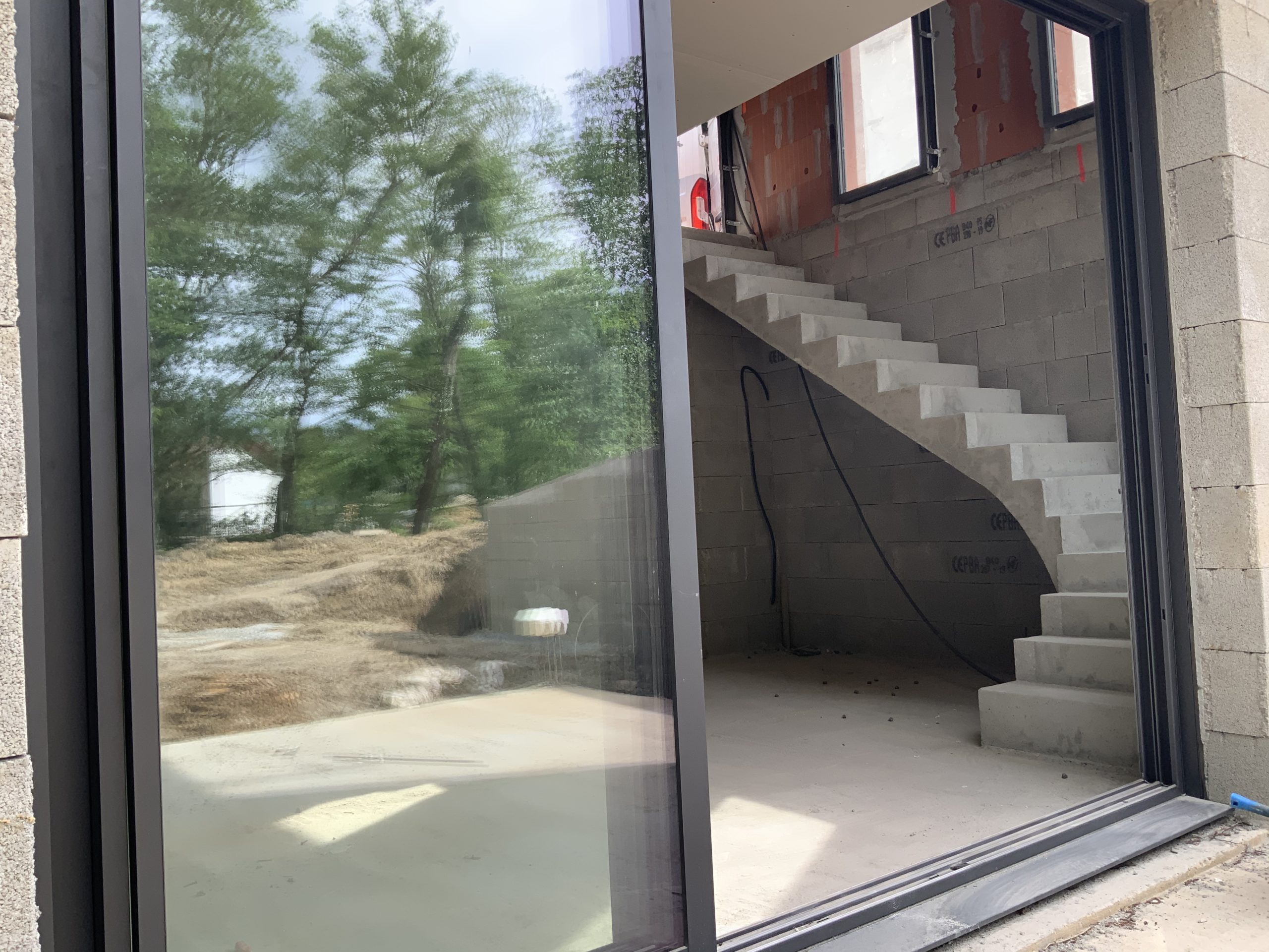 Salon avec escalier béton dans une maison