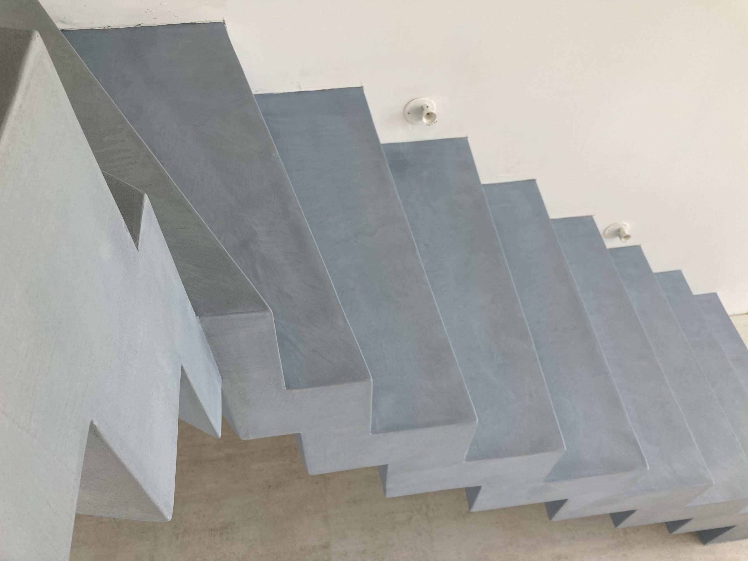 couleur gris stratus d'un escalier balancé un quart tournant en béton ciré sur le bassin d'Arcachon
