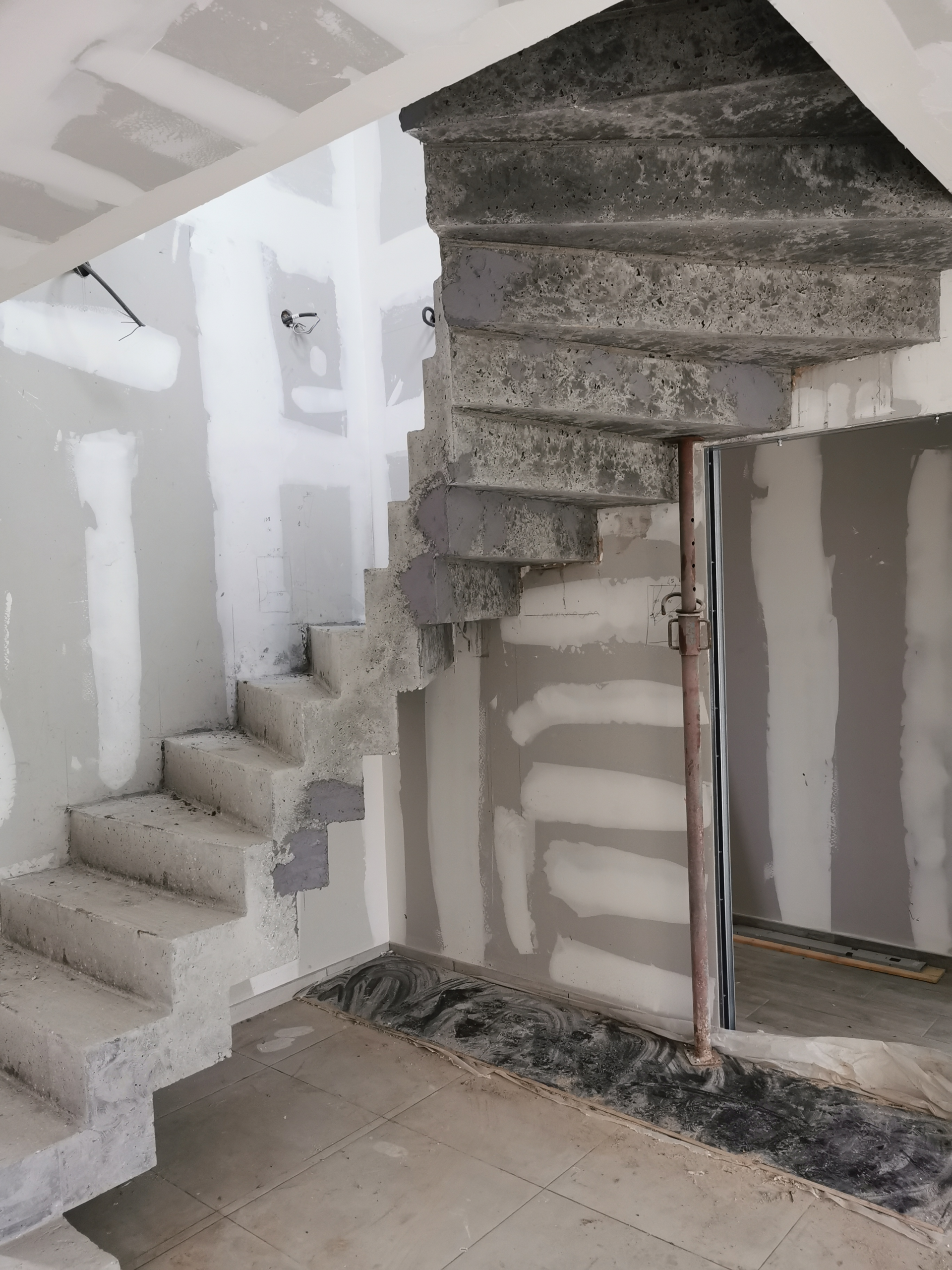 dessous d'un escalier en béton avec une lumière en arc de cercle pour un particulier