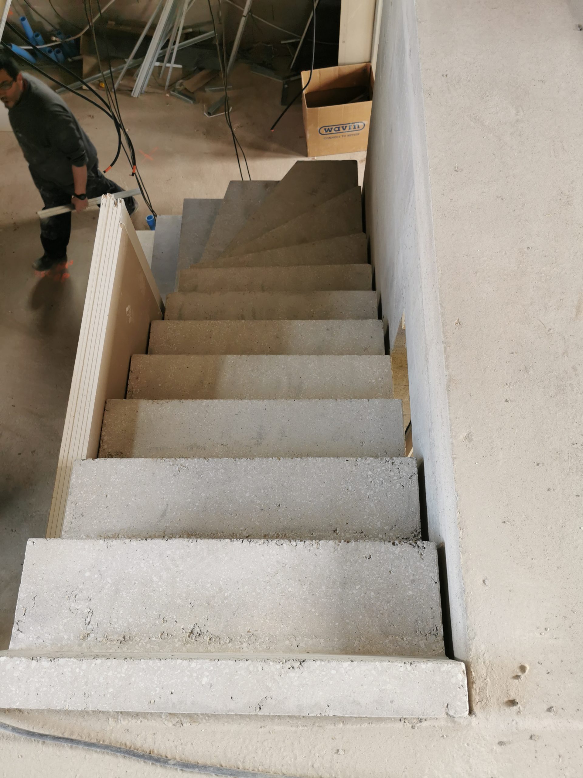 Vue de dessus d'un escalier, avec lumière central venant juste d'être décoffré dans une maison en construction.