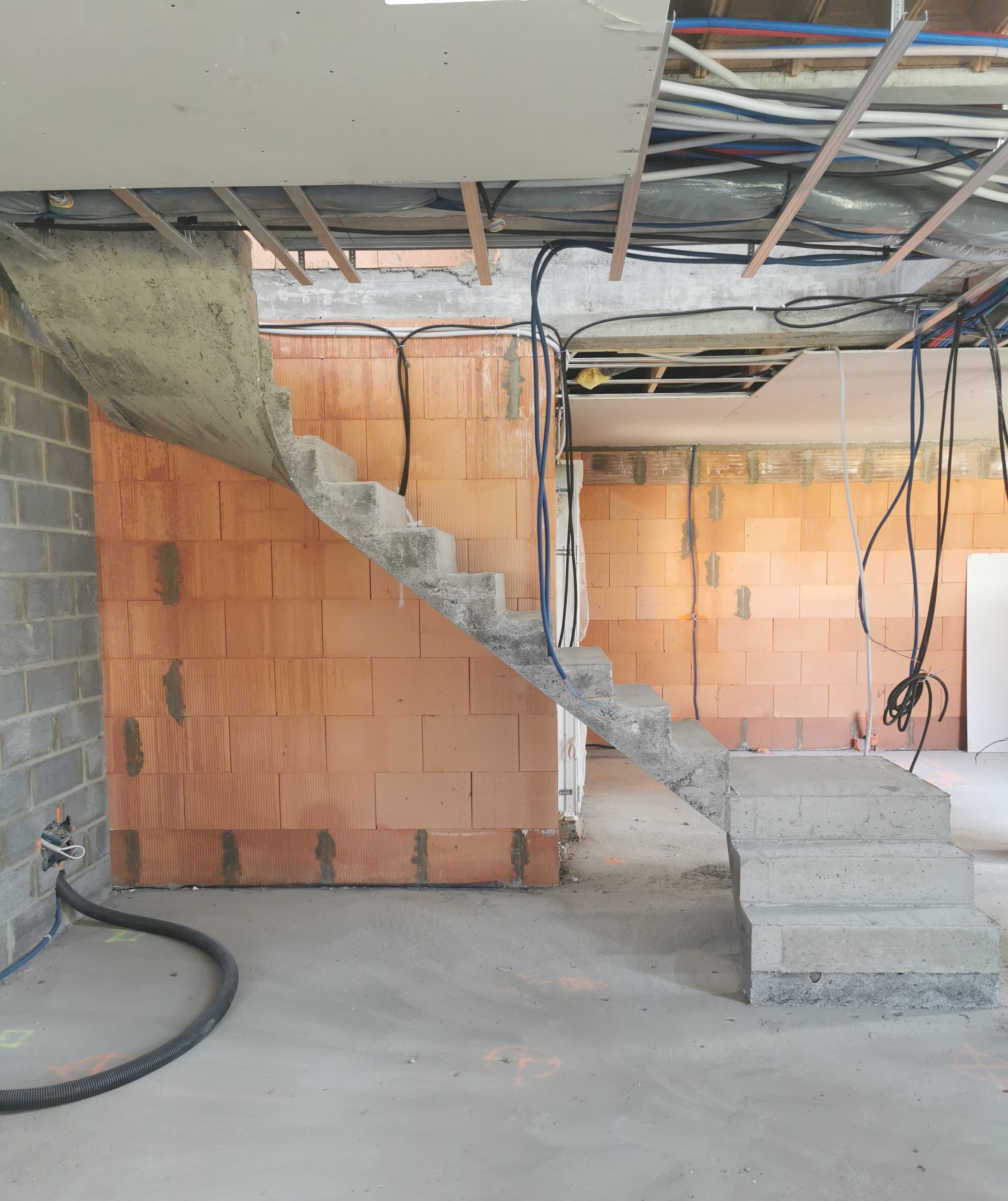 Vue de face d'un escalier intérieur d'une maison en béton brut de décoffrage pour un constructeur à Lesquin près de Lille (59).