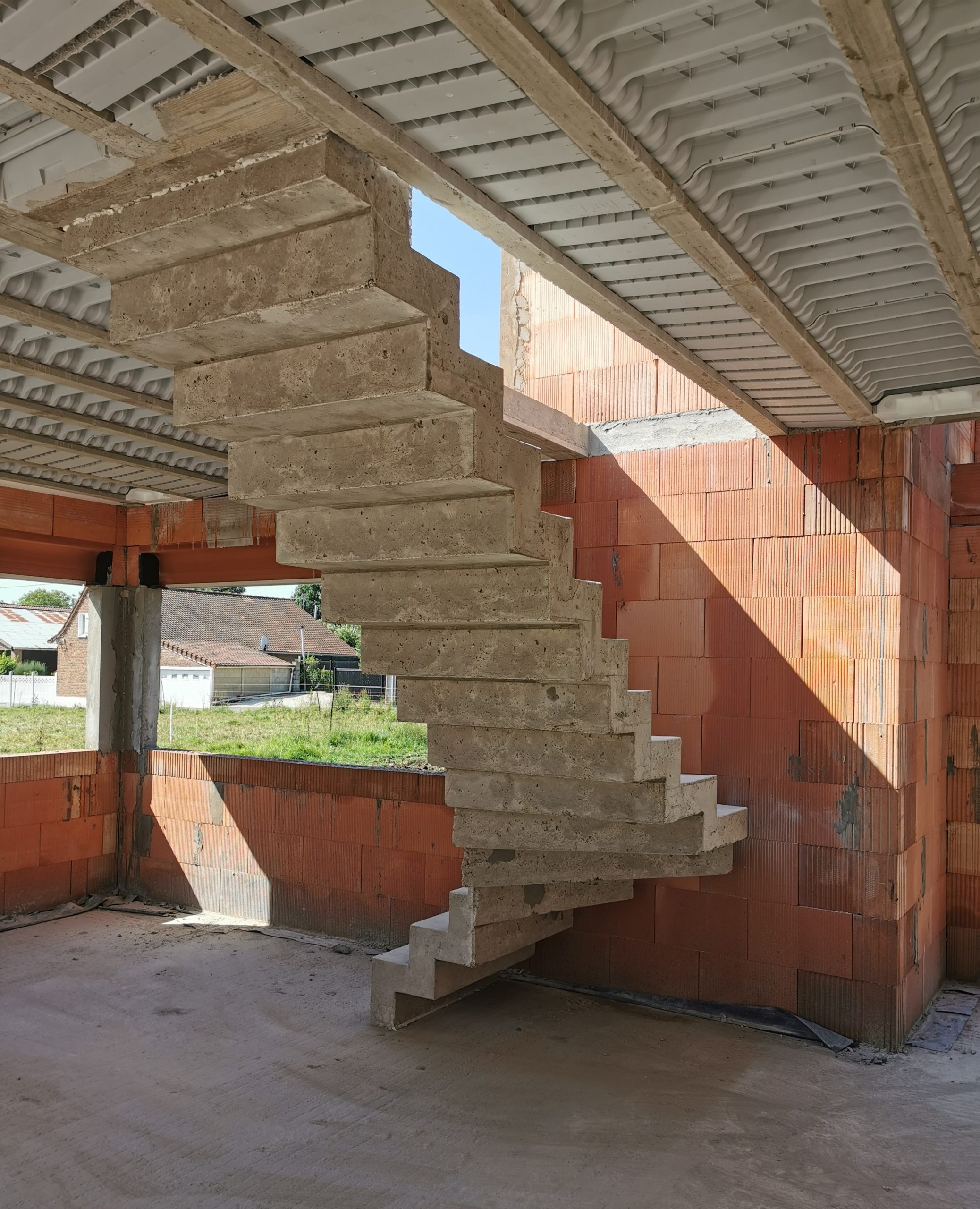 Vue par derrière, d'un escalier venant d'être décoffré dans une habitation en cours de construction.