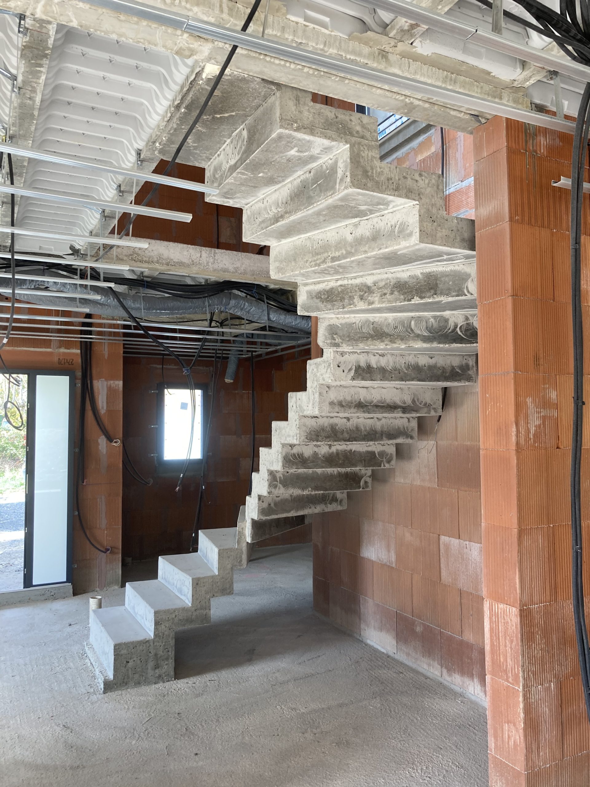 Escalier à crémaillère deux quarts tournants en béton brut de décoffrage, à Pompignac près de Bordeaux.