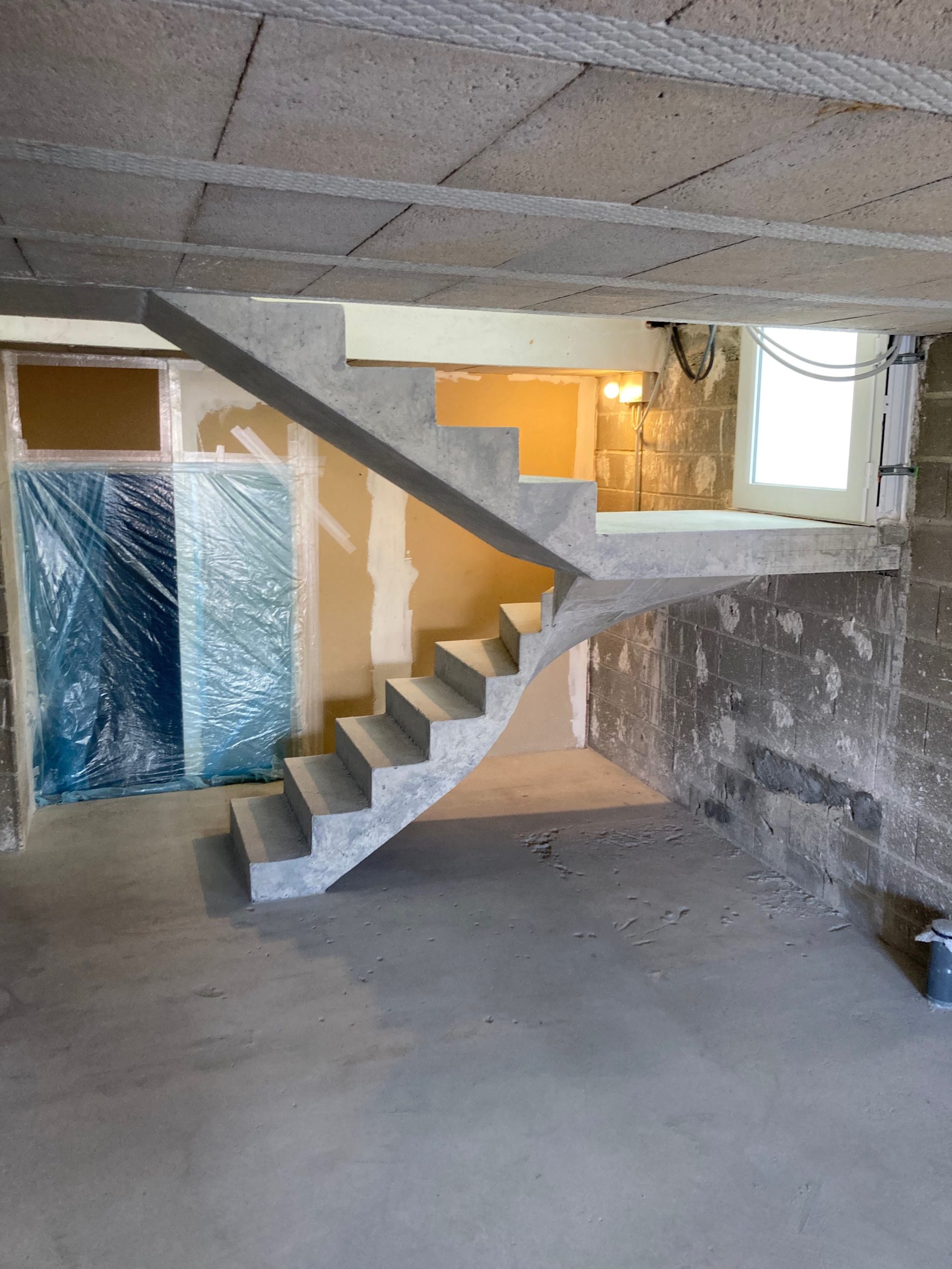 Structure en béton venant juste d'être décoffré, dont le temps de coffrage est de 1 jour et demi. Escalier à paillasse situé à Saint-Junien près de Limoges dans le département de la Haute-Vienne.
