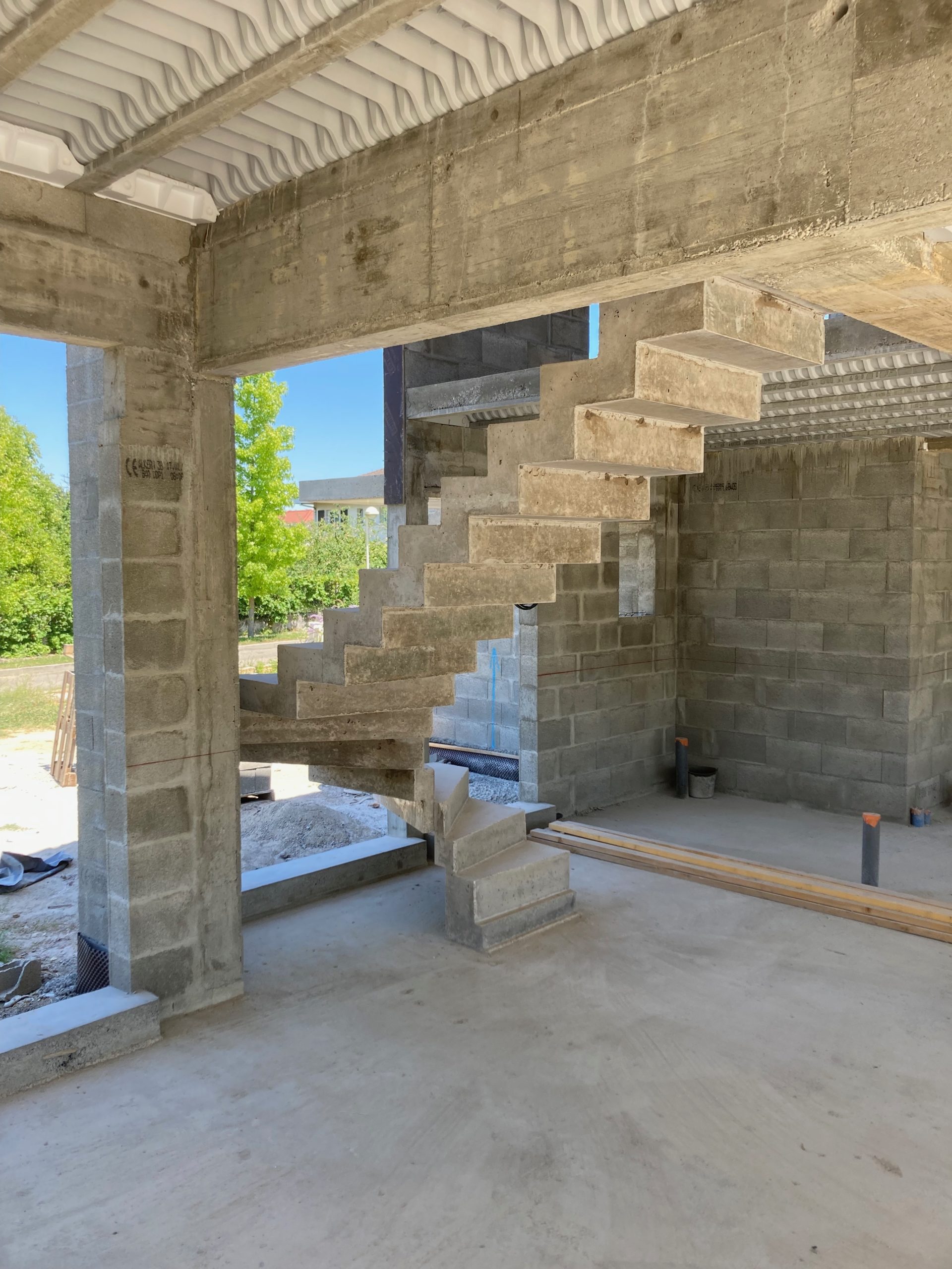 Vue par derrière d'un escalier à crémaillère en béton brut de décoffrage à Brive-la-Gaillarde à côté de Limoges et Clermont-Ferrand.