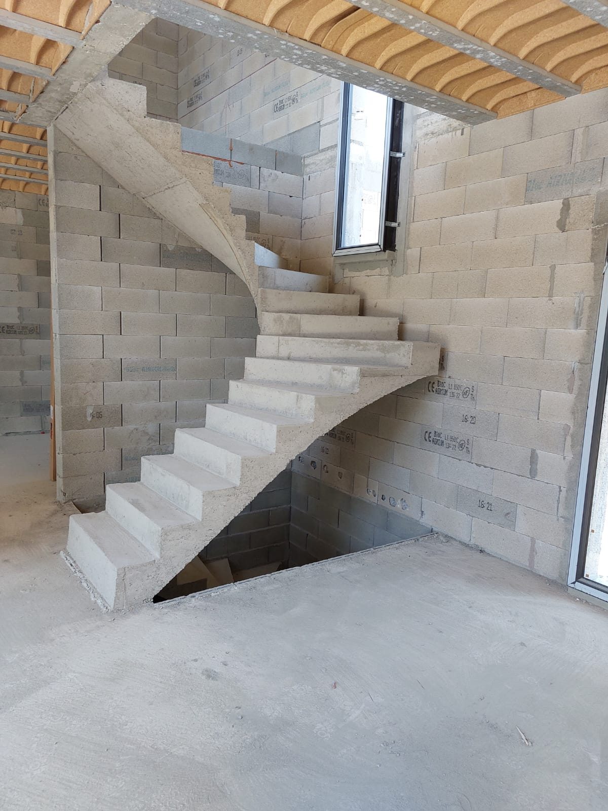 Escalier à paillasse un quart tournant en béton brut, situé à Toulouse entre Agen et Carcassonne. Matériau étant à la fois fortement résistant et durable.