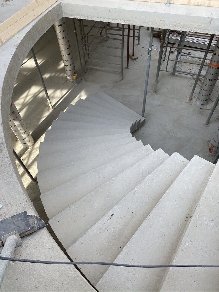 Vue du dessus d'un escalier semi hélicoïdal en béton brut de décoffrage, dans une habitation, en région Provence-Alpes-Côte d'Azur.