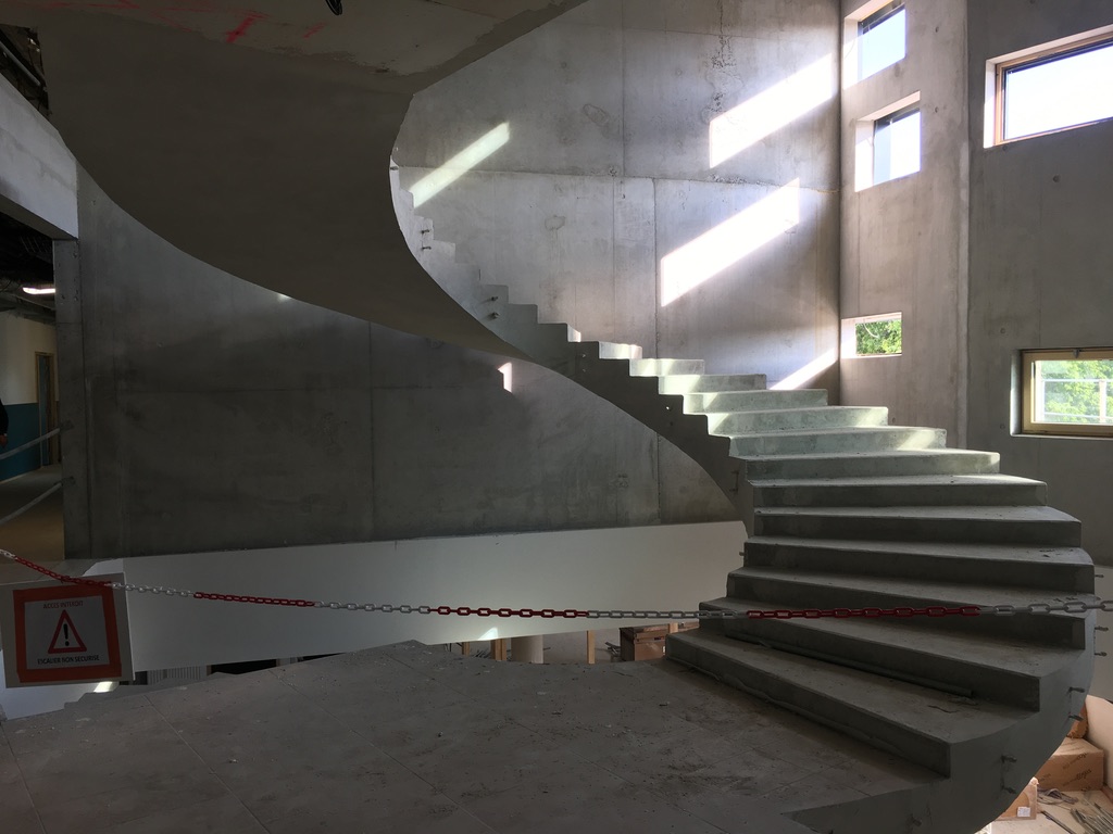 Escalier majestueux de sept mètres en béton brut, construit sur deux étages, dans un collège à Nîmes entre Montpellier et Avignon.