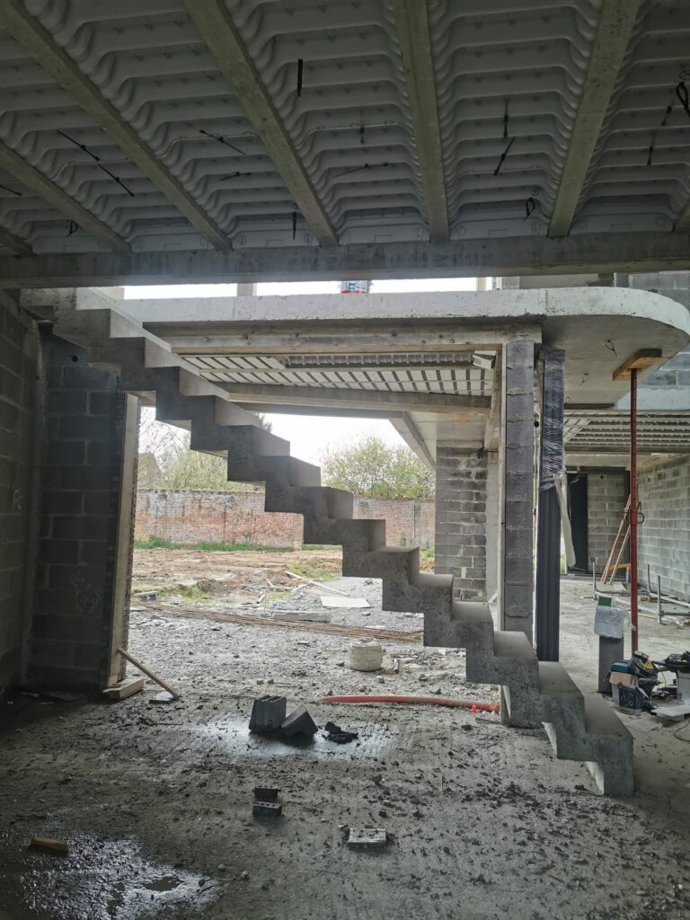 Escalier à crémaillère en beton ciré coulé à la toupie, dans un chantier en cours d'exécution, en région Hauts-de-France.