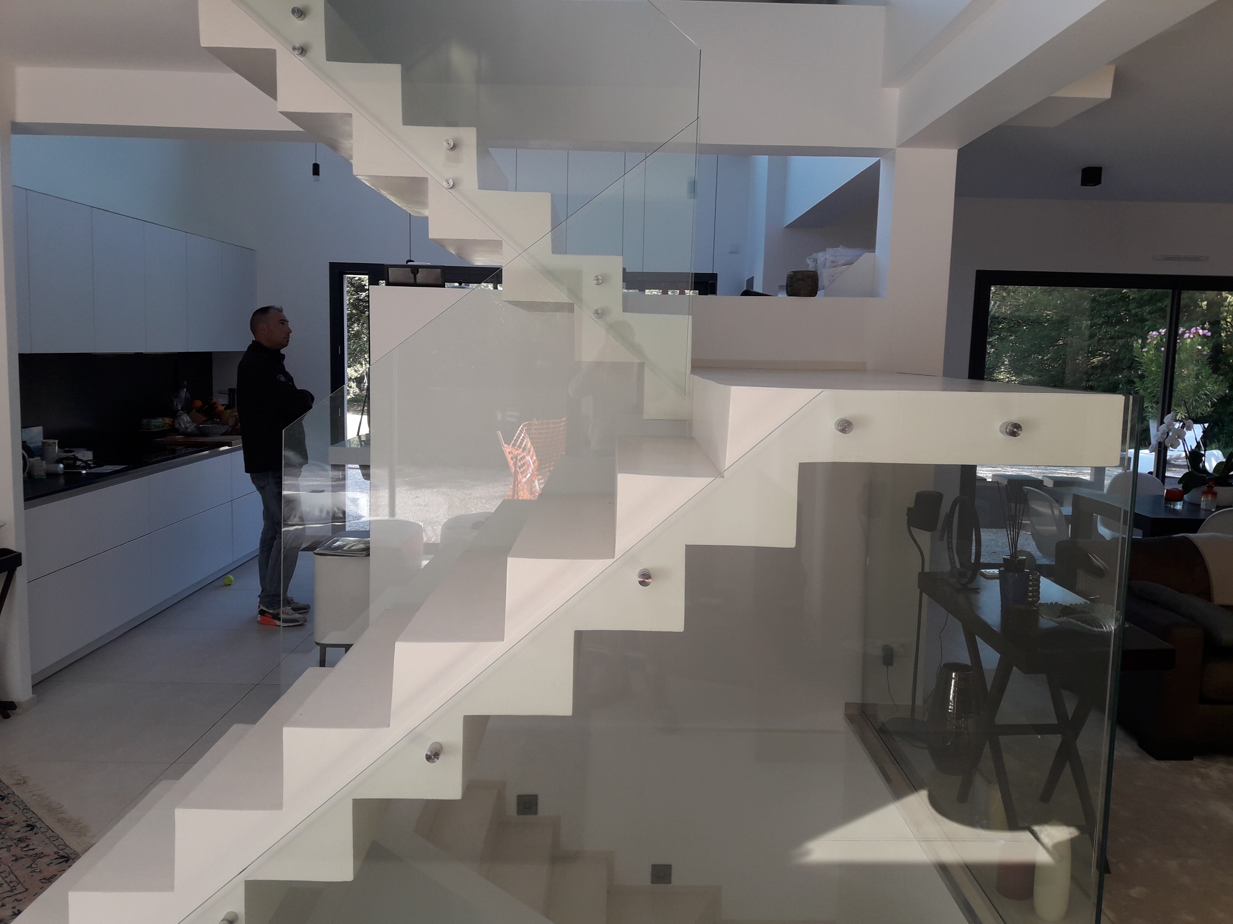 audacieux  escalier crémaillère avec palier intermédiaire en béton ciré vernis soyeux couleur everest Blanc pur, à Saint remy l honnore en région parisienne.  pour un constructeur