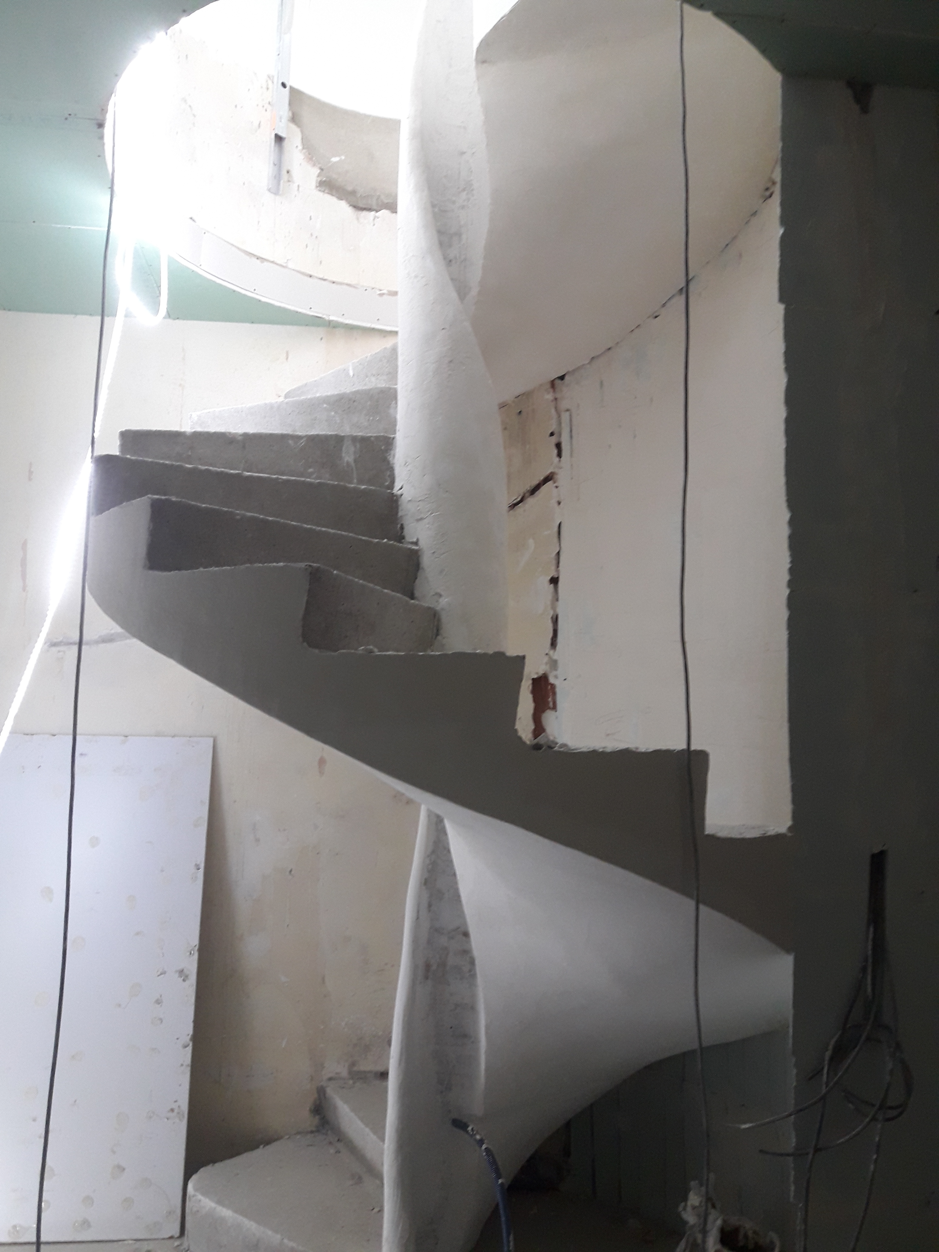 audacieux  escalier hélicoïdal avec garde corps intérieur  en béton brut de décoffrage  Paris pour un particulier