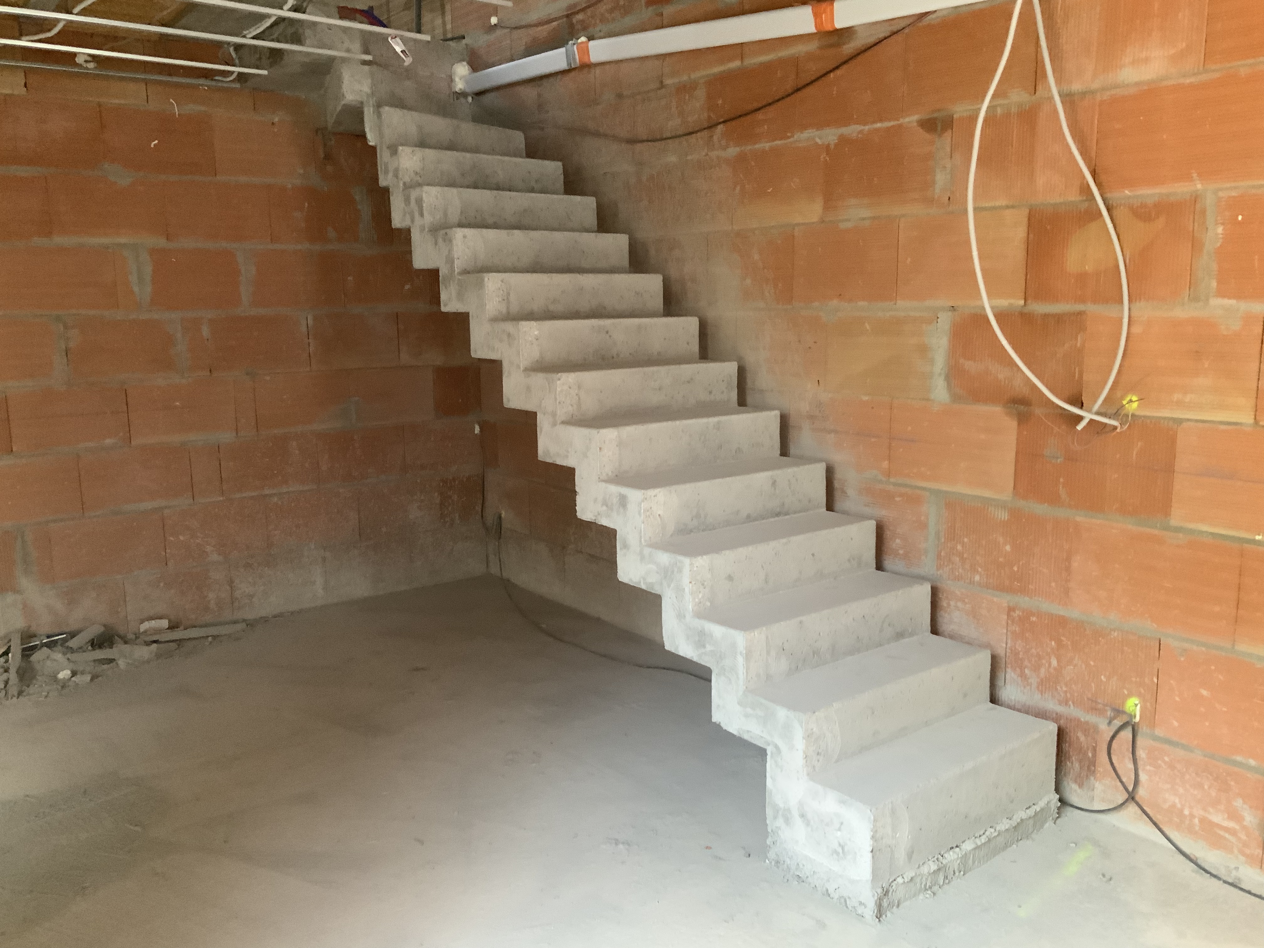 Départ de l'escalier avec sa première marche haute où à été pris en compte la réservation pour le futur plancher chauffant du rez de chaussé de la maison