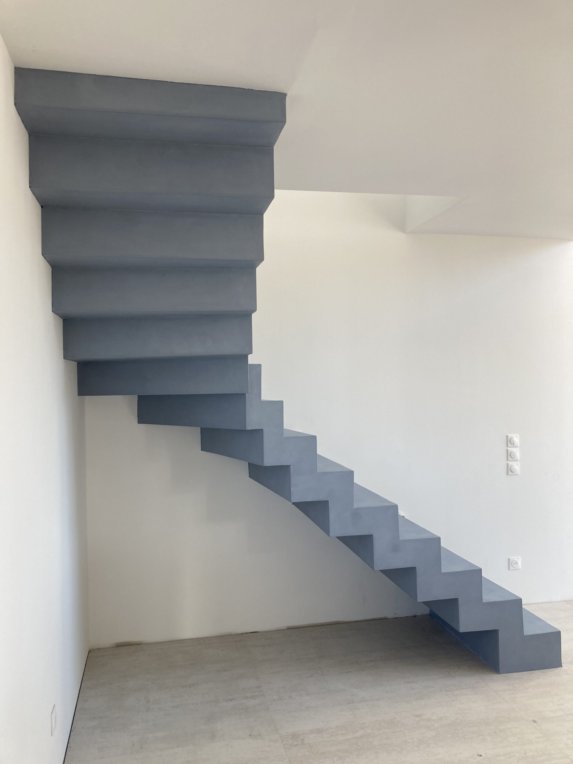dessous en béton ciré d'un escalier contemporain couleur gris bleuté en Aquitaine