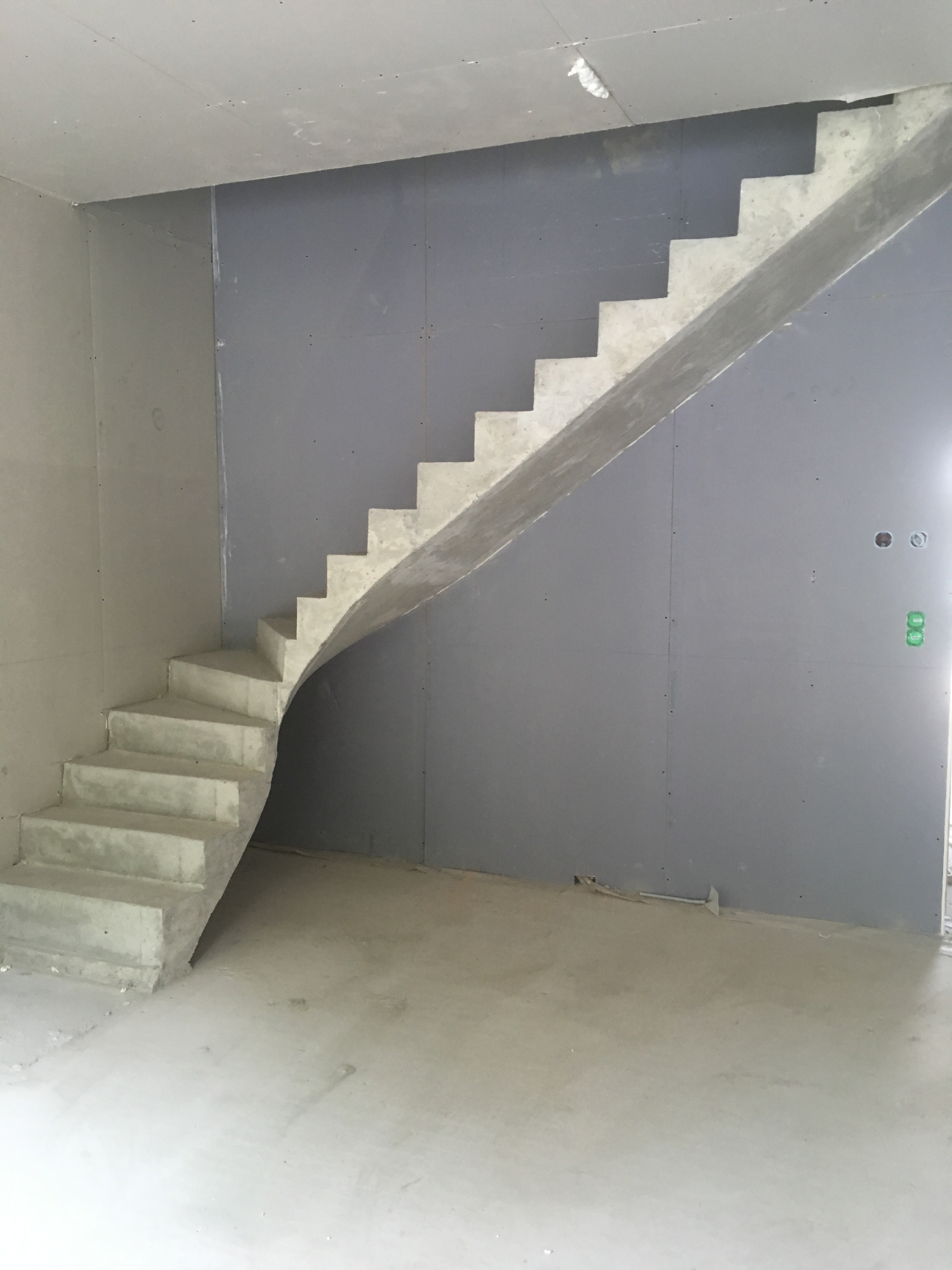 elégant escalier à paillasse un quart tournant en béton brut de décoffrage  à Talence près de Bordeaux  pour un constructeur