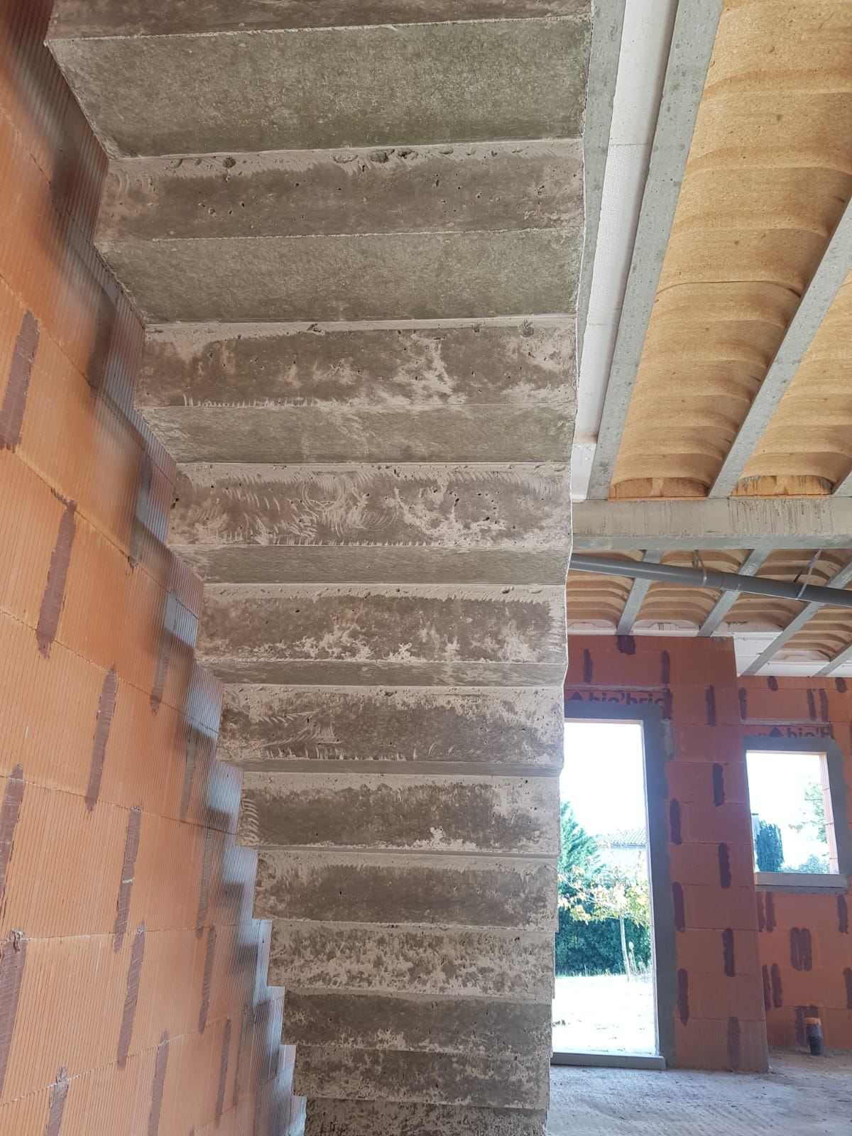 elégant escalier crémaillère d'une salle à manger en béton brut de décoffrage  à Rouffiac tolosan près de Toulouse pour un particulier