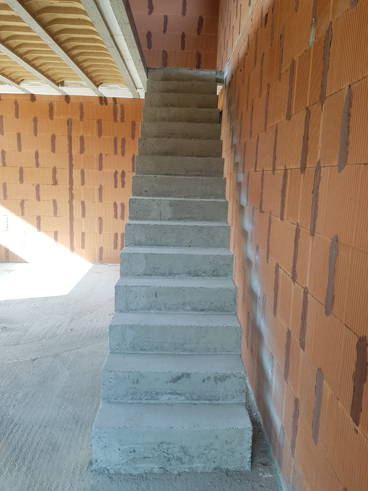 elégant escalier crémaillère d'une salle à manger en béton brut de décoffrage  à Rouffiac tolosan près de Toulouse pour un particulier