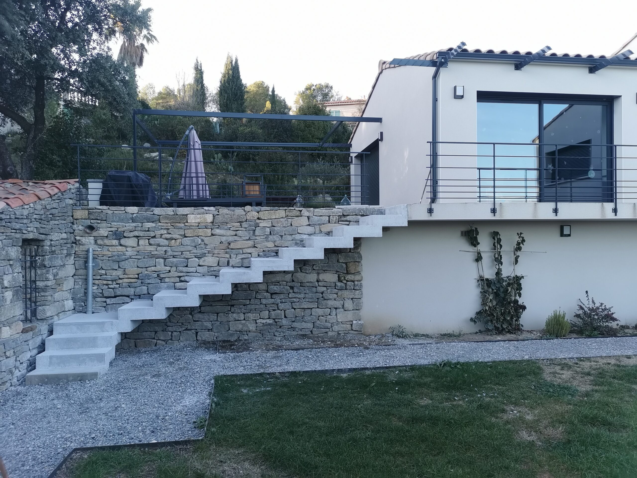 Escalier à crémaillère avec palier intermédiaire, en béton brut de décoffrage, dans une villa près de Pérols et Lattes.