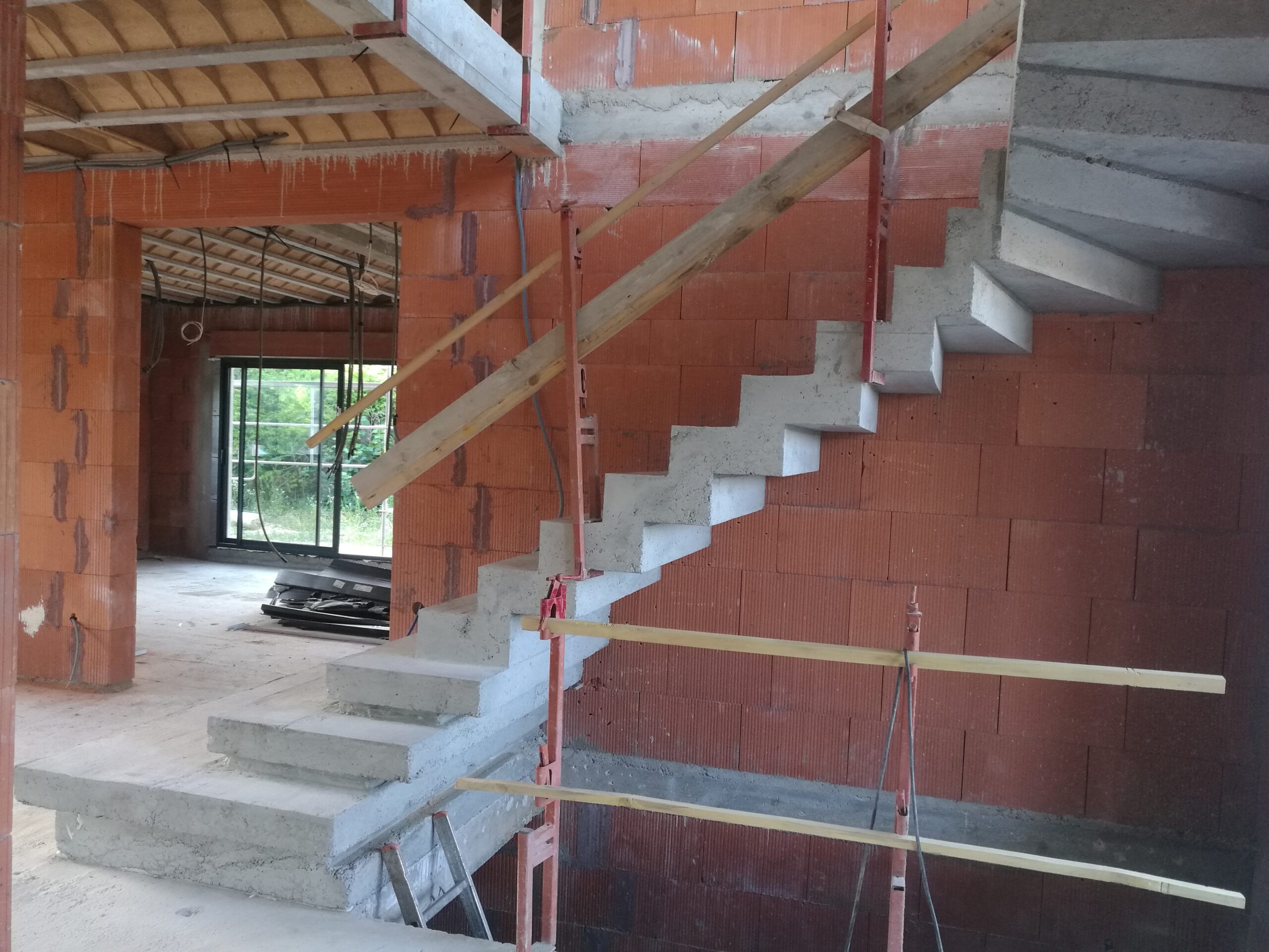 Escalier à crémaillère un quart tournant en béton massive, dans une maison individuelle, près d'Orly et Créteil. Grand choix de finitions pour les surfaces.