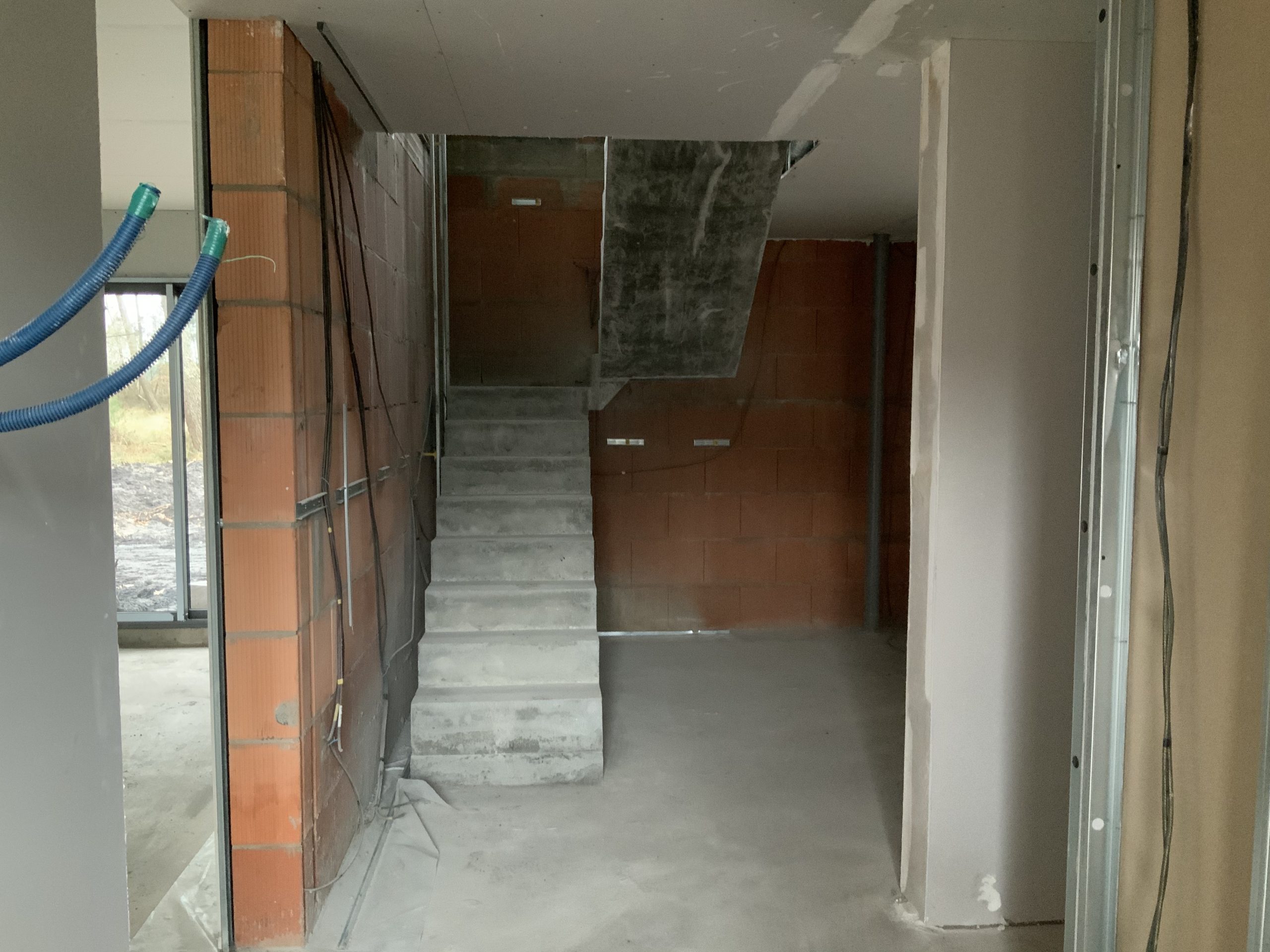 Escalier en béton brut avec deux volée droite et deux paliers intermédiaires dans une maison individuelle en construction près de Bordeaux