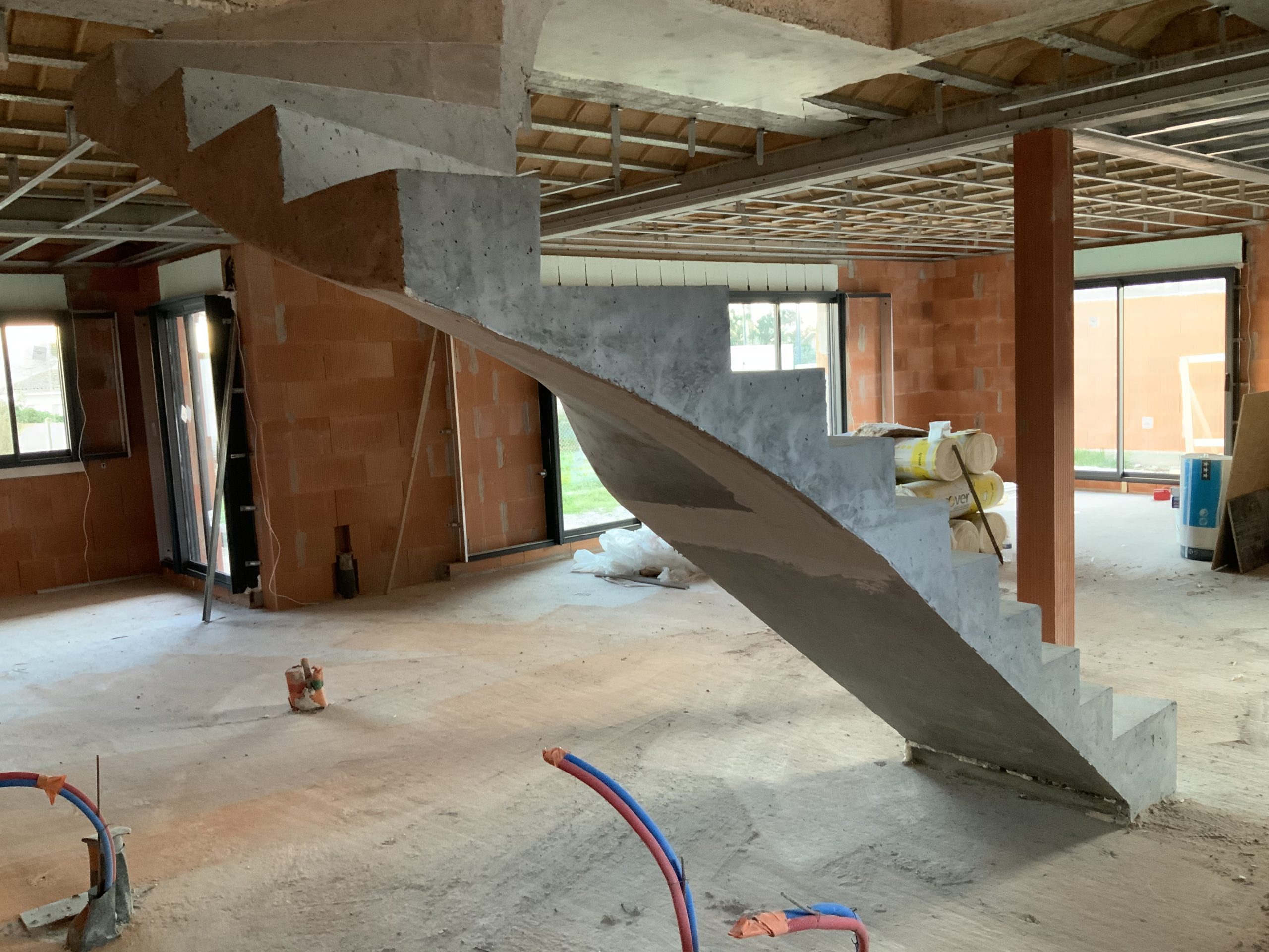 Escalier tournant deux quart balancé suspendu dans une maison en brique