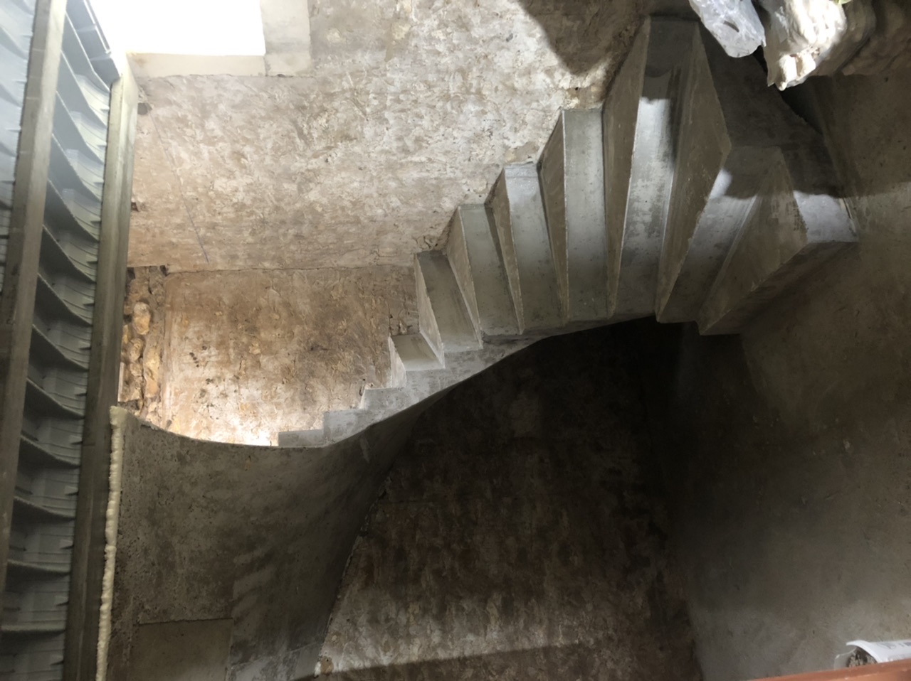 Escalier trois quart tournant qui ressemblant à un escalier hélicoïdal avec des bords extérieurs droits et une lumière rectangulaire