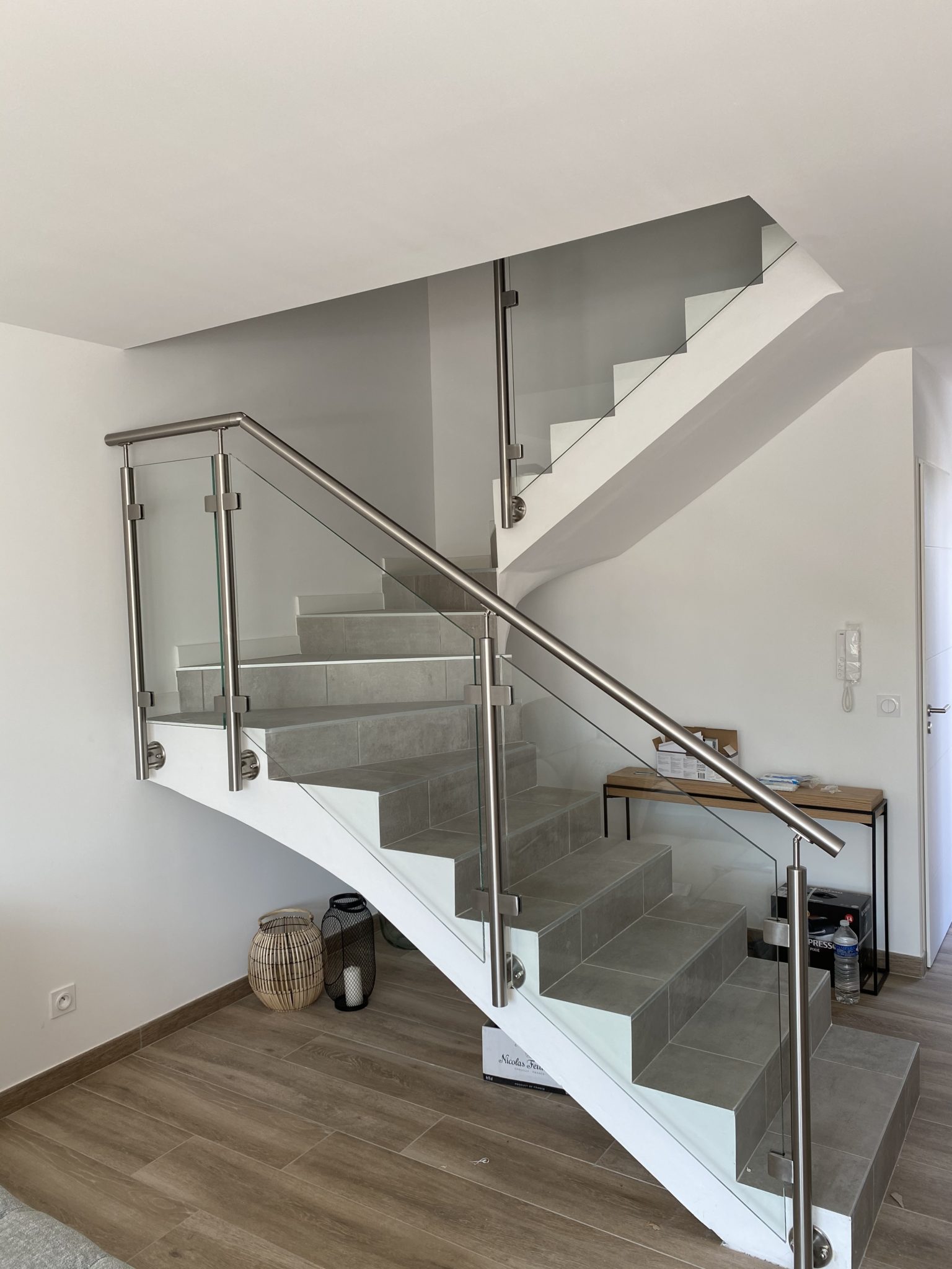 Garde-corps en inox en verre d'un escalier à paillasse en béton Entre