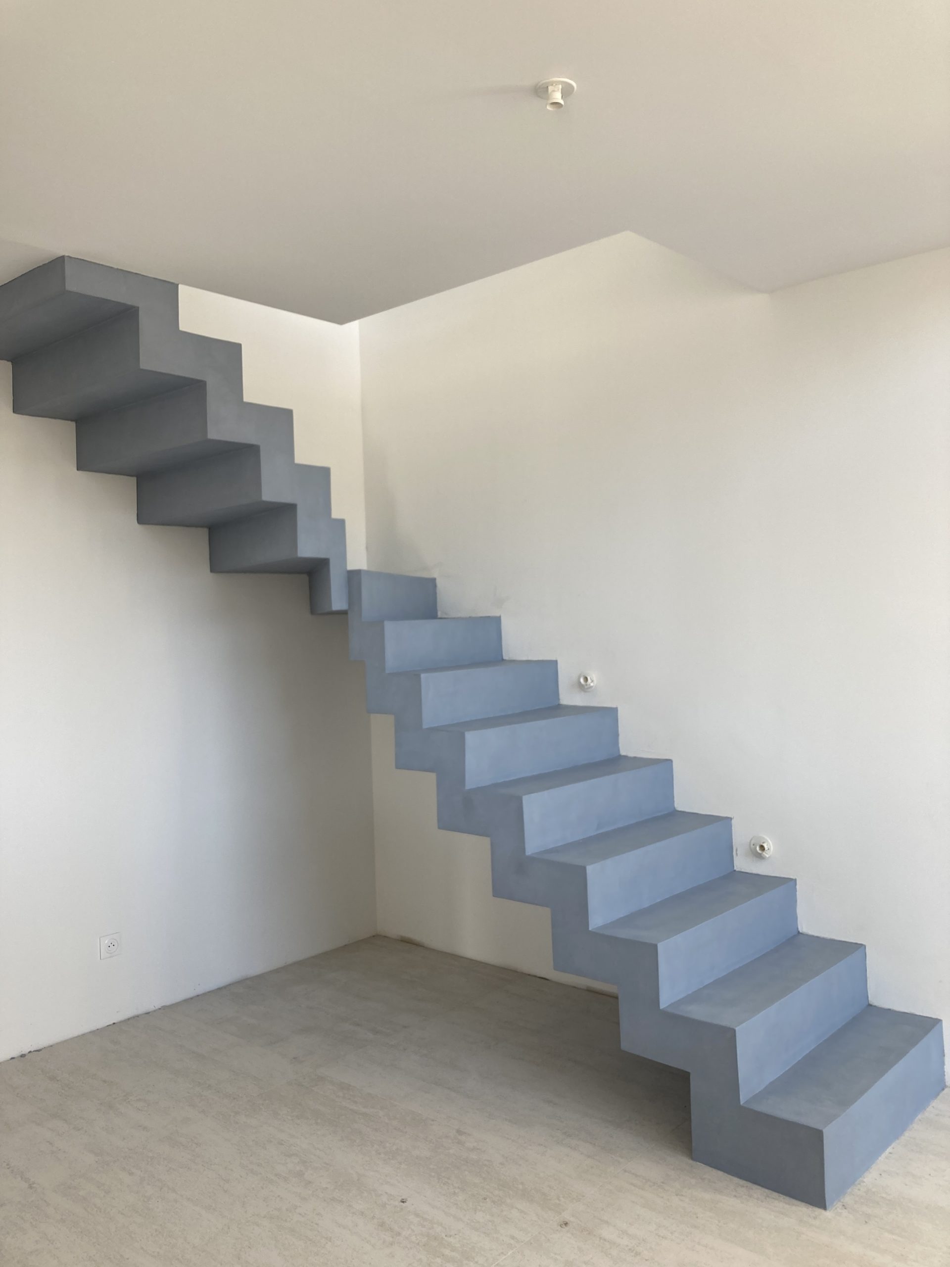 magnifique béton ciré gris d'un escalier design en forme de L à côté de Bordeaux