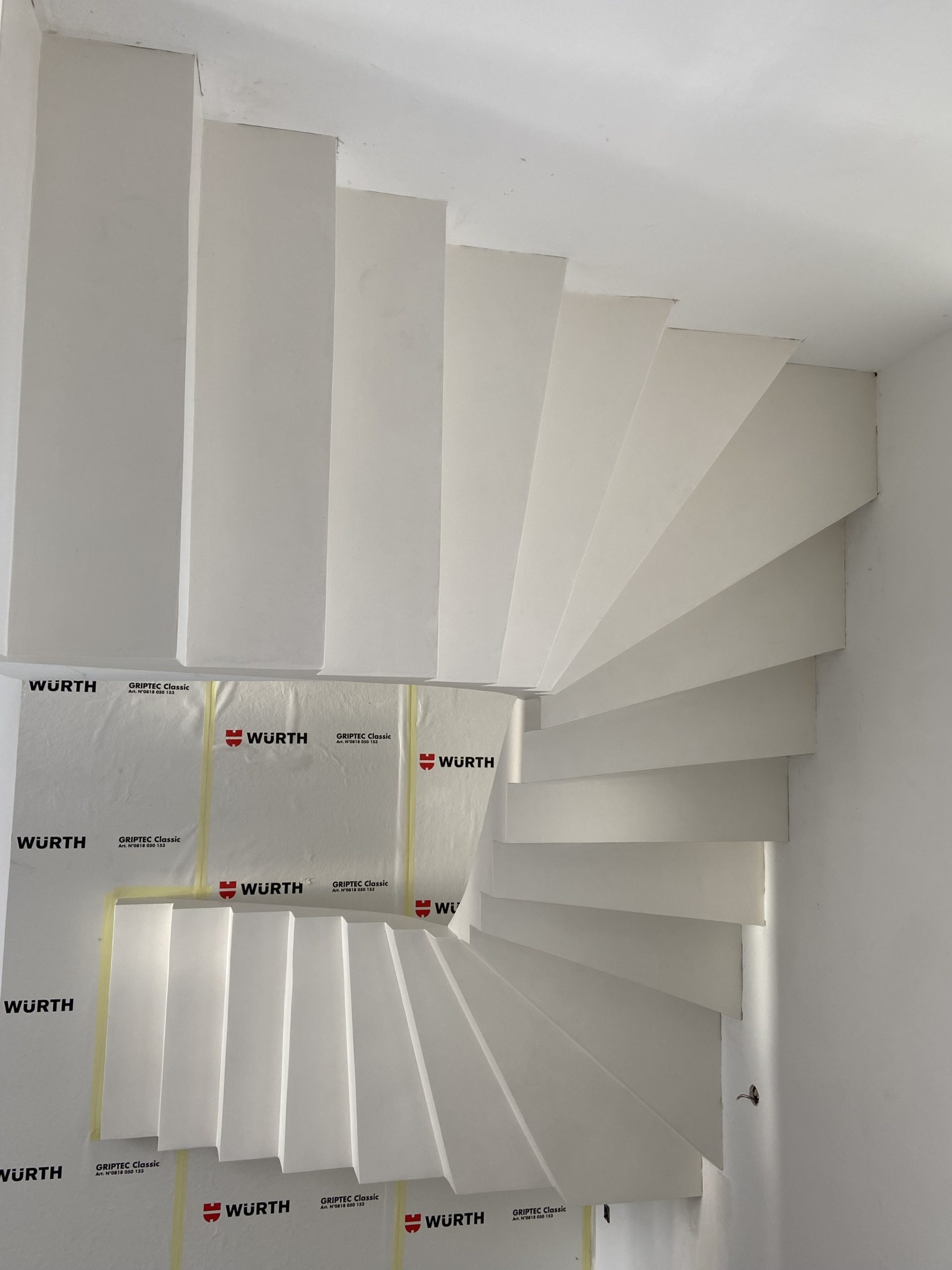 Montée d'un escalier béton à paillasse, deux quarts tournants le long d'un mur, dans une maison individuelle à Pin-balma près de Toulouse, dans la Haute-Garonne.
